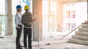 Asian contractor and engineer inspecting material in construction.