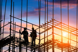2-construction-workers-on-scaffolding-during-sunset