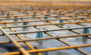 Rebar laid overtop concrete.